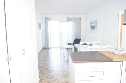 a kitchen with white cabinets and a table at Torre Luquillo in La Manga del Mar Menor