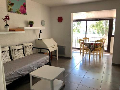 ein Wohnzimmer mit einem Sofa und einem Tisch in der Unterkunft Appartement 239 Les Salicornes in Arles