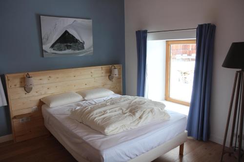 a bed in a bedroom with a large window at Chalet avec vue imprenable in Montvalezan