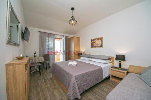 a bedroom with a bed and a desk and a couch at Apartments & rooms Merita in Brela