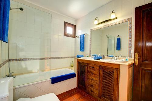 een badkamer met een bad, een wastafel en een spiegel bij CASA ACEQUIA in Tinajo