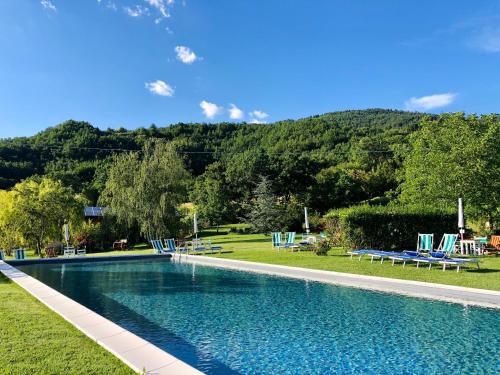 a swimming pool with chairs and a mountain in the background at Agriturismo Tripala in Minucciano