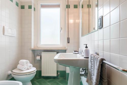 uma casa de banho branca com um lavatório e um WC em appartamento casa stefi n1 em Malcesine