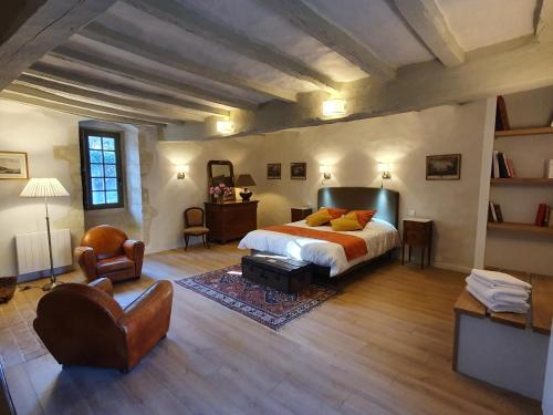 a large bedroom with a bed and a chair at Manoir du Bellay in Montreuil-Bellay