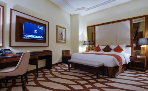 a bedroom with a bed and a desk and a tv at Bayat Hotel in Khamis Mushayt