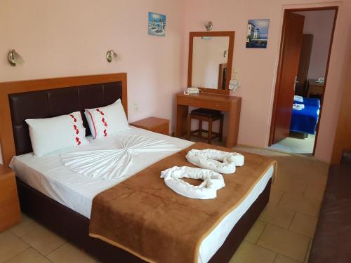 a bedroom with a bed with two towels on it at Smaro Studios in Chrysi Ammoudia