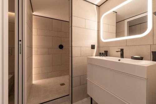 La salle de bains blanche est pourvue d'un lavabo et d'une douche. dans l'établissement B5 Loft Duplex 175Blo-Paris Convention, à Paris