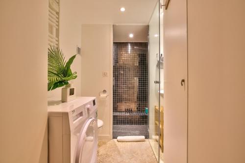 y baño con ducha, aseo y lavamanos. en New Stunning 4 Bdrs Apt, With AC – Le Marais, en París