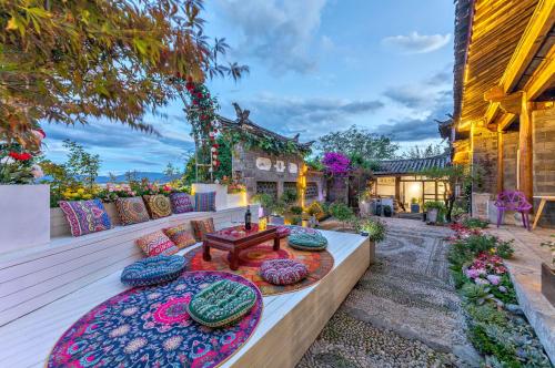 un patio con mesa y almohadas. en Lijiang Mountain View Boutique Inn en Lijiang
