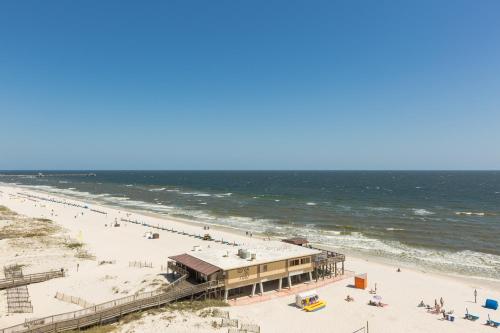 Blick auf einen Strand mit einem Gebäude und das Meer in der Unterkunft Seawind Condominiums in Gulf Shores