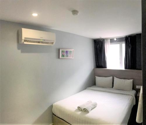 a bedroom with a white bed with a air conditioner at Hotel 99 Pusat Bandar Puchong in Puchong