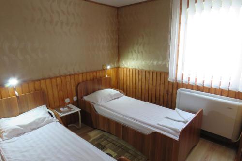 a small room with two beds and a window at Hotel Plutitor Carpatia St. Constantin in Sulina