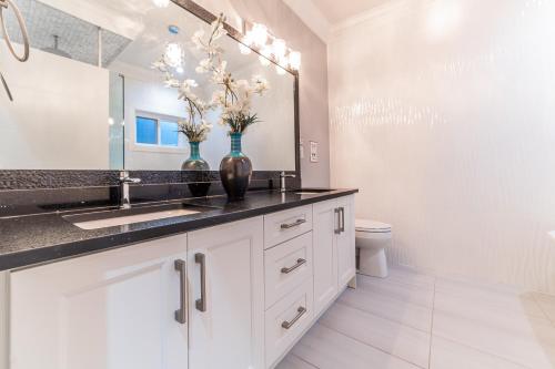 a white bathroom with a sink and a toilet at Kim's Place in Surrey