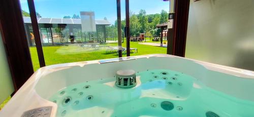 a bath tub in a room with a window at Apartamentos El Castañeu in Corao