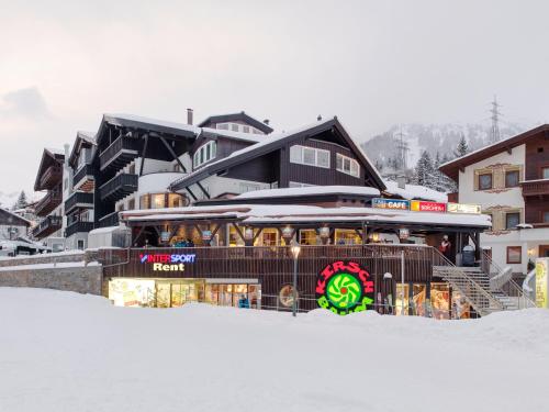 a building in the snow with a sign on it at Quality Hosts Arlberg - Hotel Bergheim in Sankt Anton am Arlberg
