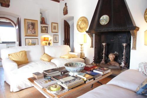 a living room with a white couch and a fireplace at Alloggio Castello di Loreto in Todi