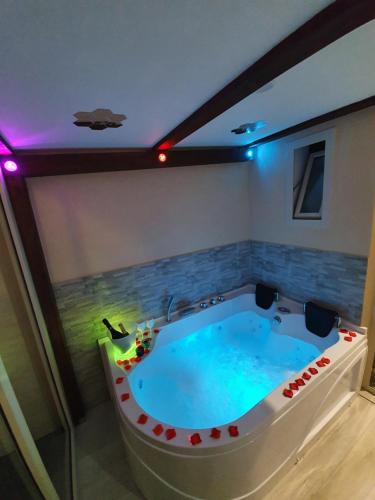 a large bath tub in a room with purple lights at Scilla's Dream in Scilla