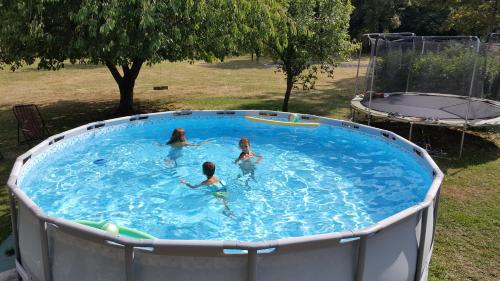 Trois filles nagent dans une piscine dans une cour dans l'établissement Manoir du Bellay, à Montreuil-Bellay