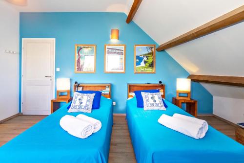 twee bedden in een kamer met blauwe muren bij Récif - villa de charme pieds dans l'eau à Saint-Gilles-les-Bains in Saint-Gilles-les-Bains