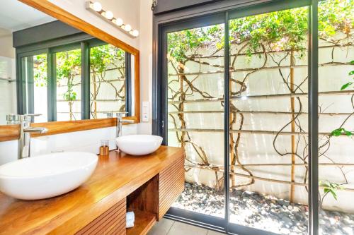 a bathroom with two sinks on a wooden counter at Récif - villa de charme pieds dans l'eau à Saint-Gilles-les-Bains in Saint-Gilles les Bains