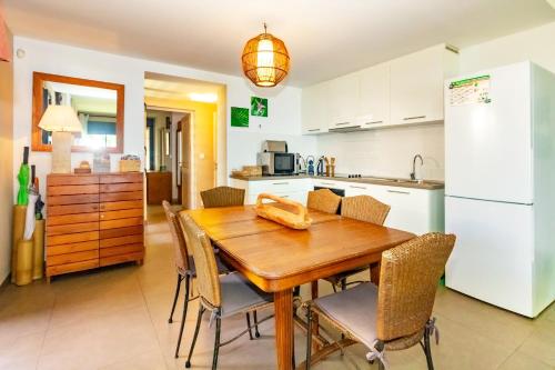 a kitchen and dining room with a wooden table and chairs at Récif - villa de charme pieds dans l'eau à Saint-Gilles-les-Bains in Saint-Gilles les Bains