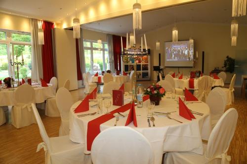a dining room with white tables and white chairs at Schlosshotel Domäne Walberberg in Bornheim