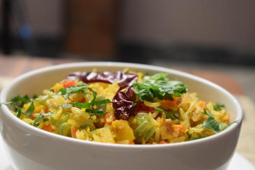 a white bowl of food with vegetables in it at Ambara Suites in Trivandrum