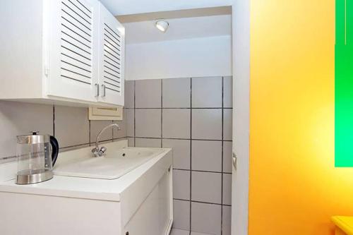 eine Küche mit einem weißen Waschbecken und einer gelben Wand in der Unterkunft Welcome to Trastevere in Rom