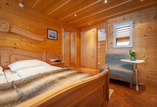a bedroom with a bed in a wooden cabin at Quality Hosts Arlberg - Hotel Bergheim in Sankt Anton am Arlberg