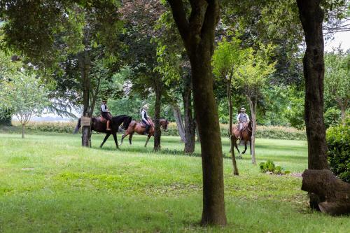 three people are riding horses in a park at Antico Borgo di Sutri in Sutri