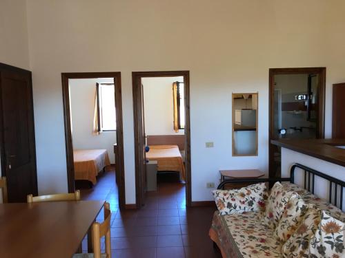 a living room with a couch and a bedroom at Borgo Spiaggia Isola Rossa in Isola Rossa