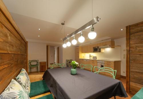 a kitchen and a dining room with a table in a room at Quality Hosts Arlberg - Hotel Bergheim in Sankt Anton am Arlberg