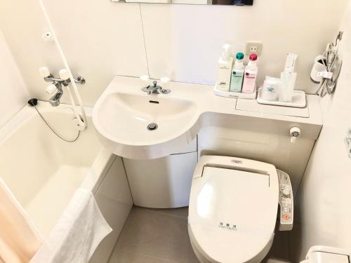Asahi City Inn Hotel في تاكاوكا: حمام صغير مع مرحاض ومغسلة
