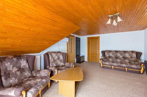a living room with couches and a wooden ceiling at Shepilska Relax Complex in Dovholuka