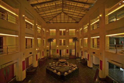 a large room with a table and palm trees in it at Renest Gandhidham in Gandhidham