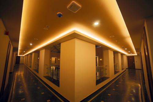 a hallway of a building with lights on the ceiling at Renest Gandhidham in Gandhidham