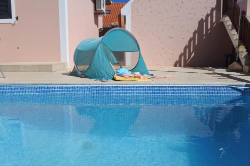 a tent is sitting next to a swimming pool at Quintinha do Álvaro - Holiday house in Santana