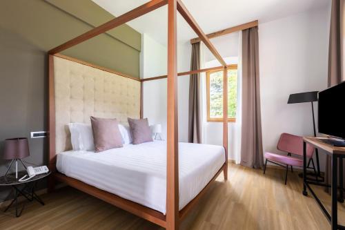 a bedroom with a bed and a desk and a television at Antico Borgo di Sutri in Sutri