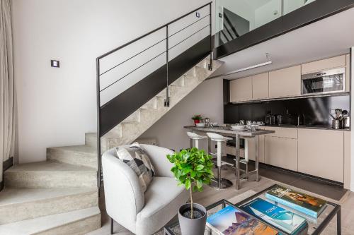 - un escalier dans un salon avec une chaise et une table dans l'établissement B6 Loft Duplex 175Blo-Paris Convention, à Paris