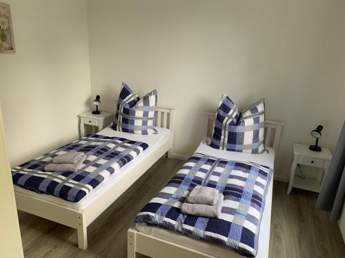 two beds with blue and white striped pillows in a room at Ferienhaus Fegebank in Nienhagen in Nienhagen
