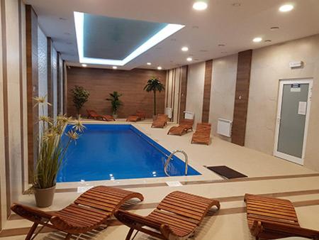 uma piscina num quarto grande com duas cadeiras em Hotel - Restauracja "SŁONECZNA" em Jarocin