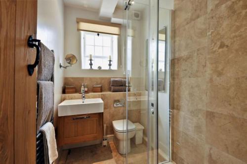 a bathroom with a toilet and a sink and a shower at Thornton in Chipping Campden