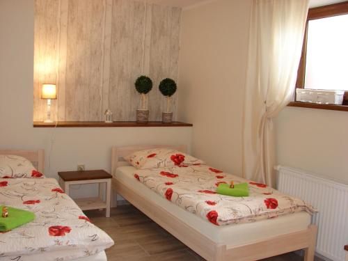 Dos camas en una habitación pequeña con flores. en Słoneczna Ostoja, en Mikołajki