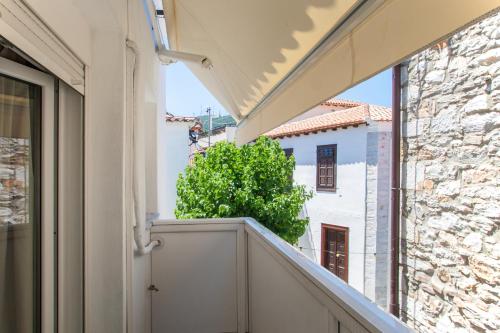 a view from the balcony of a house with a tree at Bohemian Townhouse in Skiathos Town
