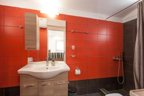 a bathroom with a sink and red tiles at Bohemian Townhouse in Skiathos Town
