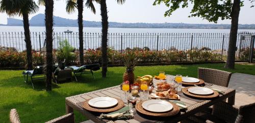 a table with food on it with a view of the water at Residence Villalsole in San Felice del Benaco