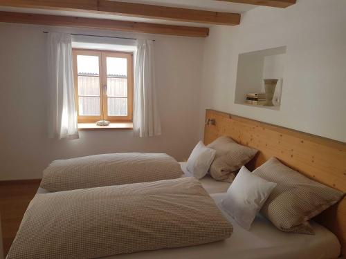 a bedroom with two beds and a window at Ferienwohnungen Garhammer_ Kreuth_ in Kreuth