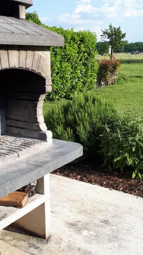 una panchina di pietra accanto a un giardino con cespugli di Villa Meli Lupi - Residenze Temporanee a Parma