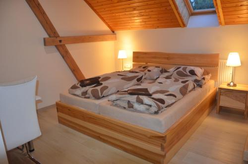 a large bed in a room with wooden ceilings at penzion U Koníčka in Strážiště