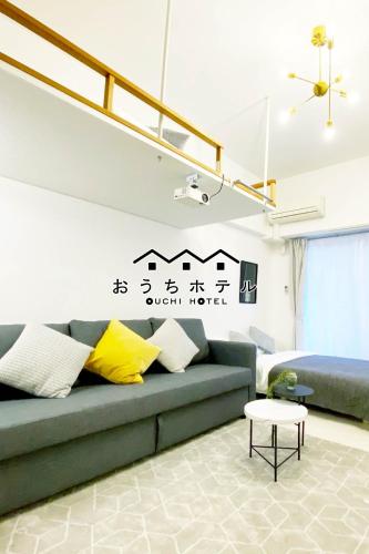 a living room with a couch and a table at OUCHI HOTEL Higashi-Hiratsuka #301 in Hiroshima